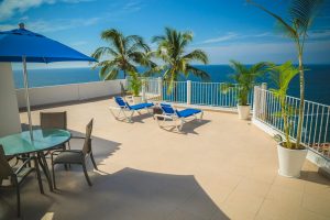 blue loungers on beige balcony beside sea landscape photography