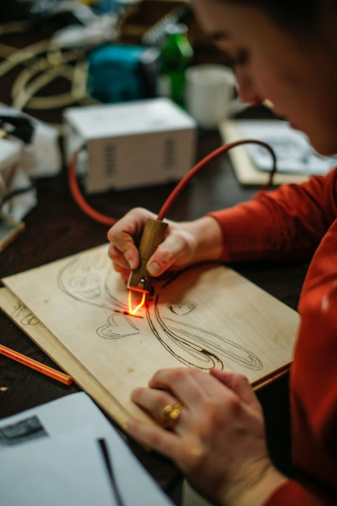 woman drawing with burner on wooden board