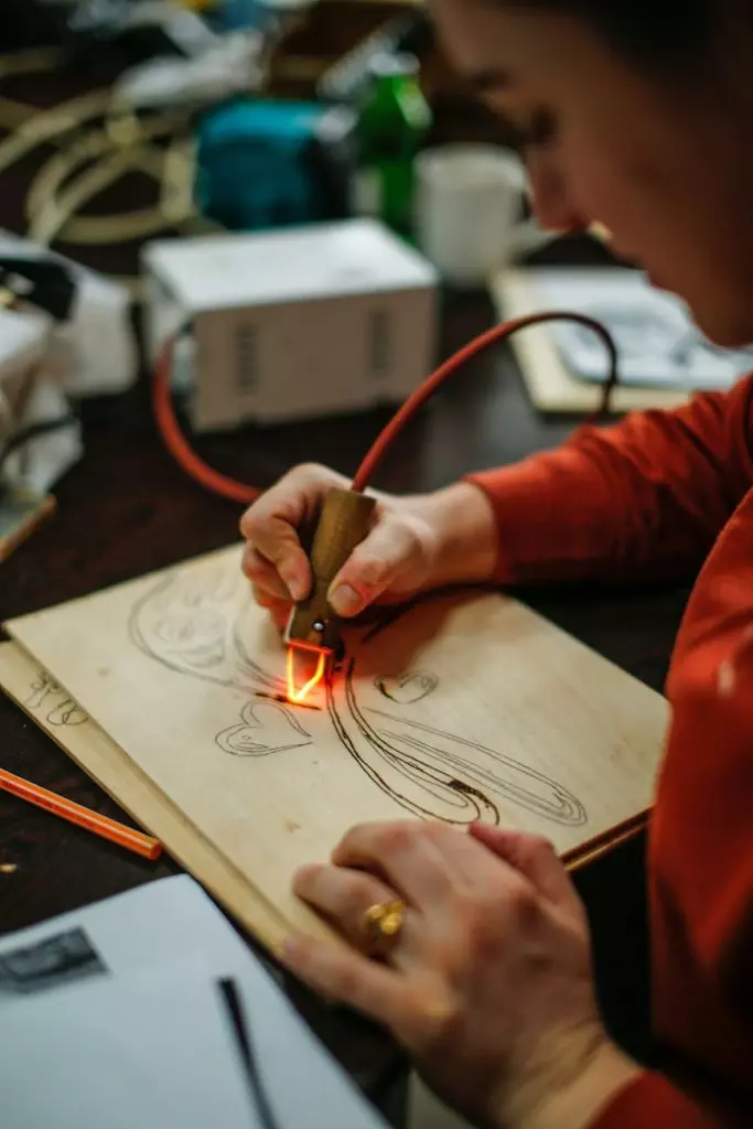 woman drawing with burner on wooden board